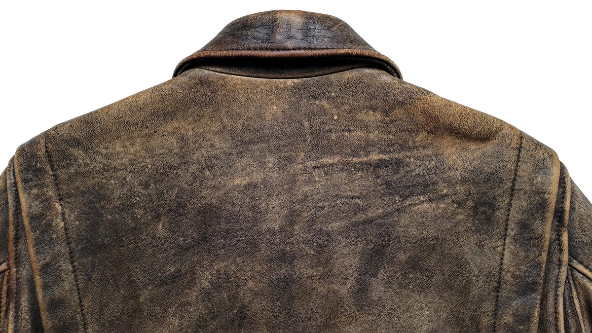 Close-up back view of a distressed brown leather jacket on a white background.