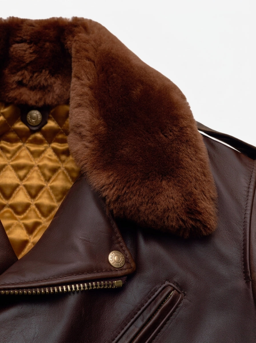 Close-up of a dark brown leather jacket featuring a thick, fluffy brown shearling-style collar and a quilted gold interior lining.