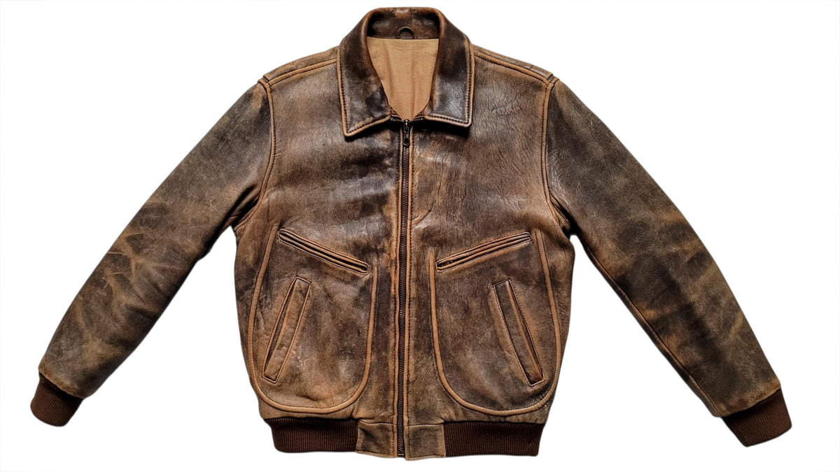 A distressed brown leather jacket with a front zipper, pointed collar, and two large front flap pockets, shown against a plain white background.