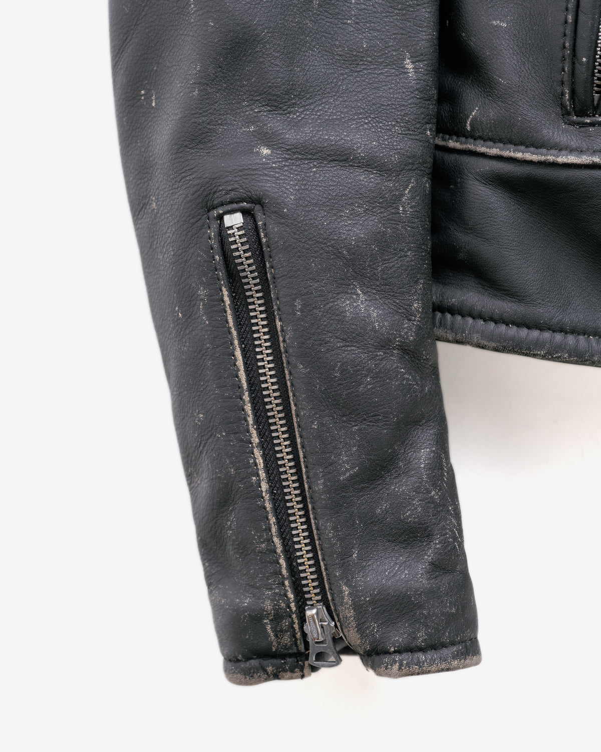 Close-up of a black leather jacket with a zipper on a white background